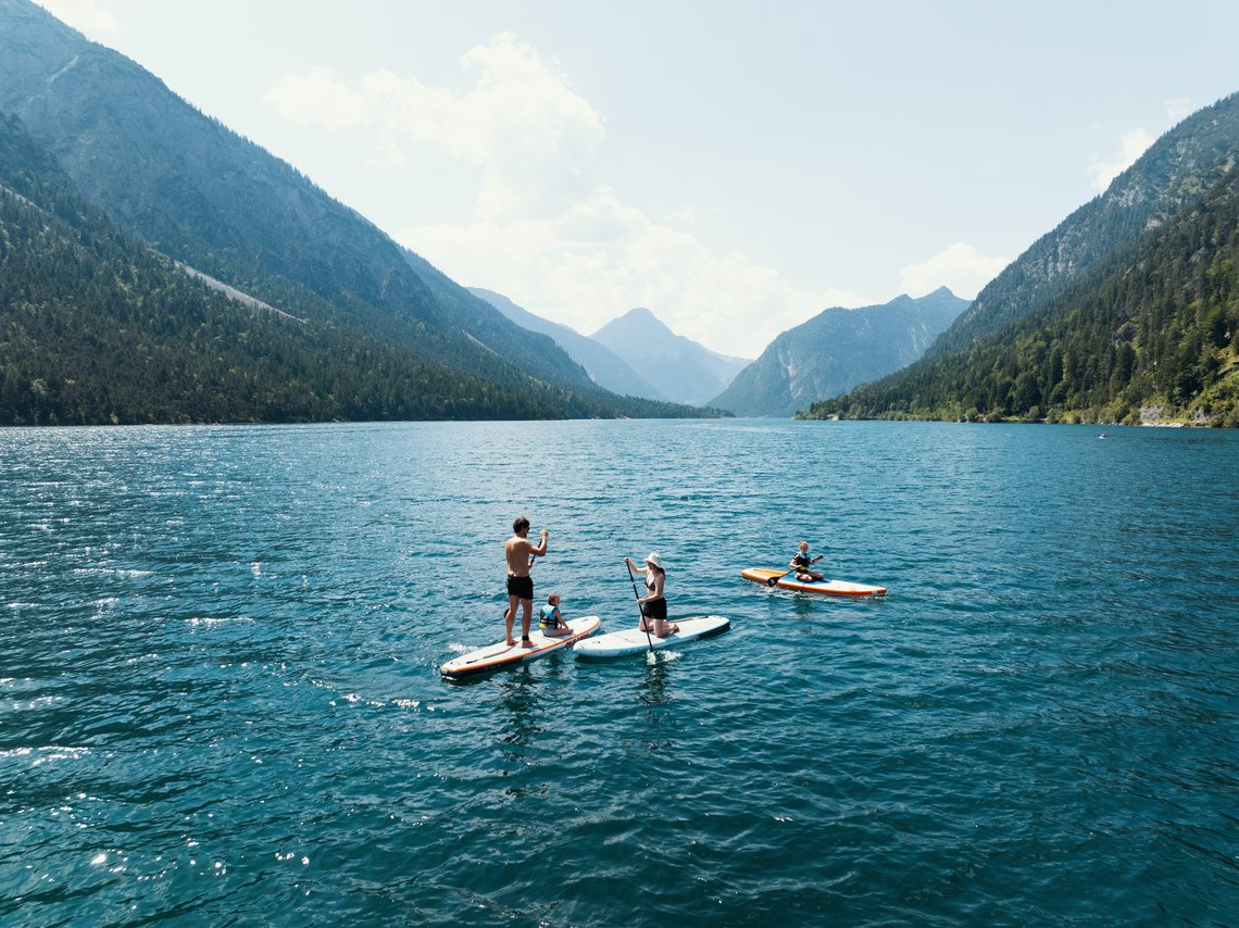 Menschen mit Stand Up Paddle auf einem Bergsee