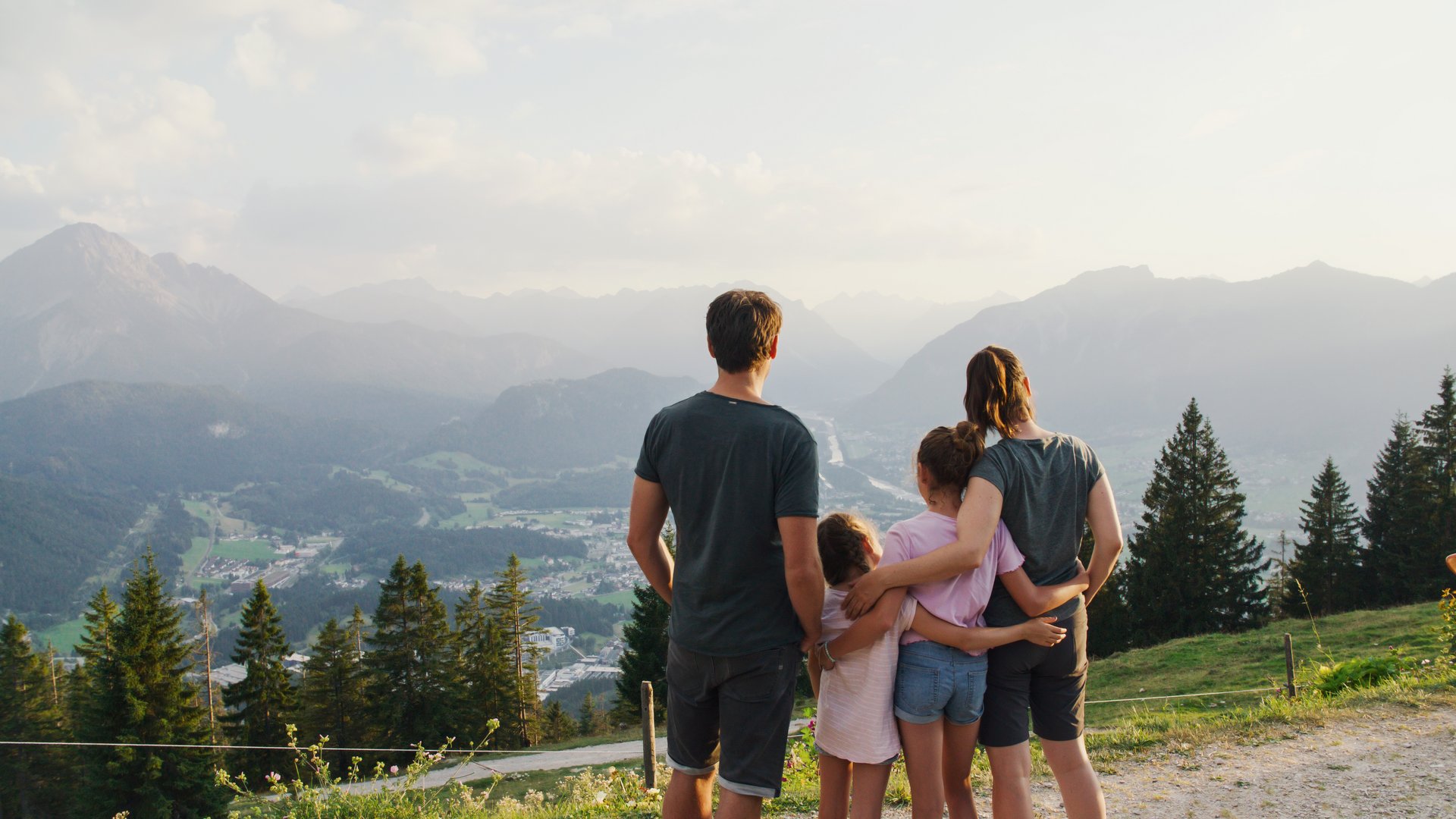 Familie von hinten mit Blick auf die umliegenden Berge